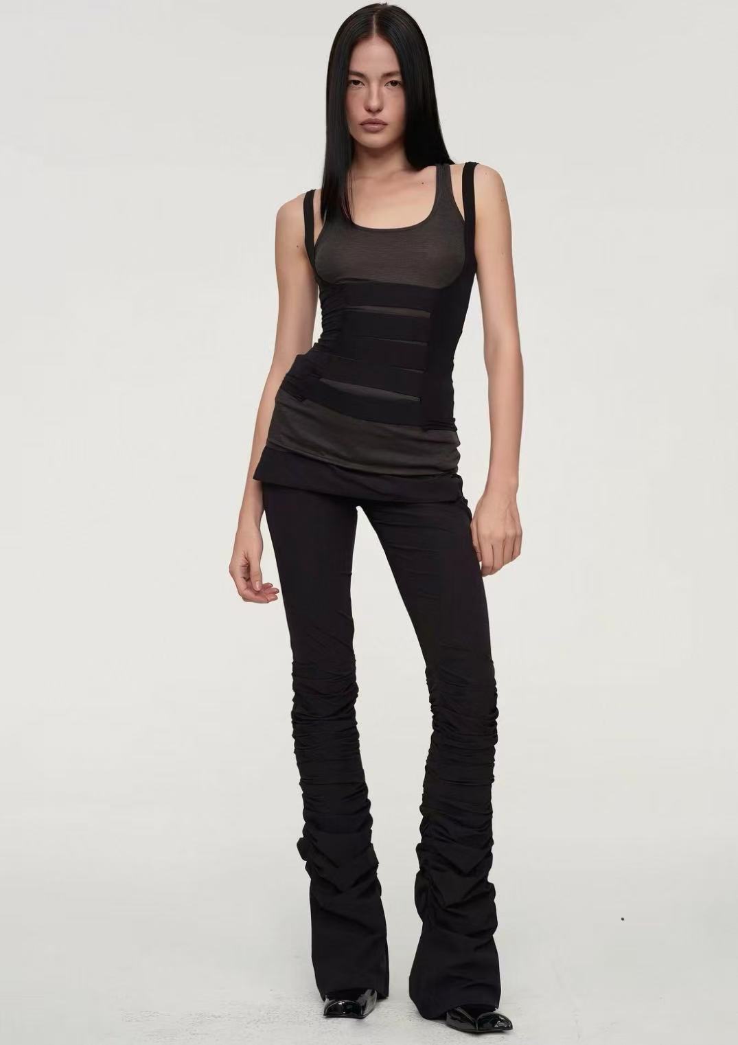 Front view of a layered charcoal and black outfit with ruched trousers