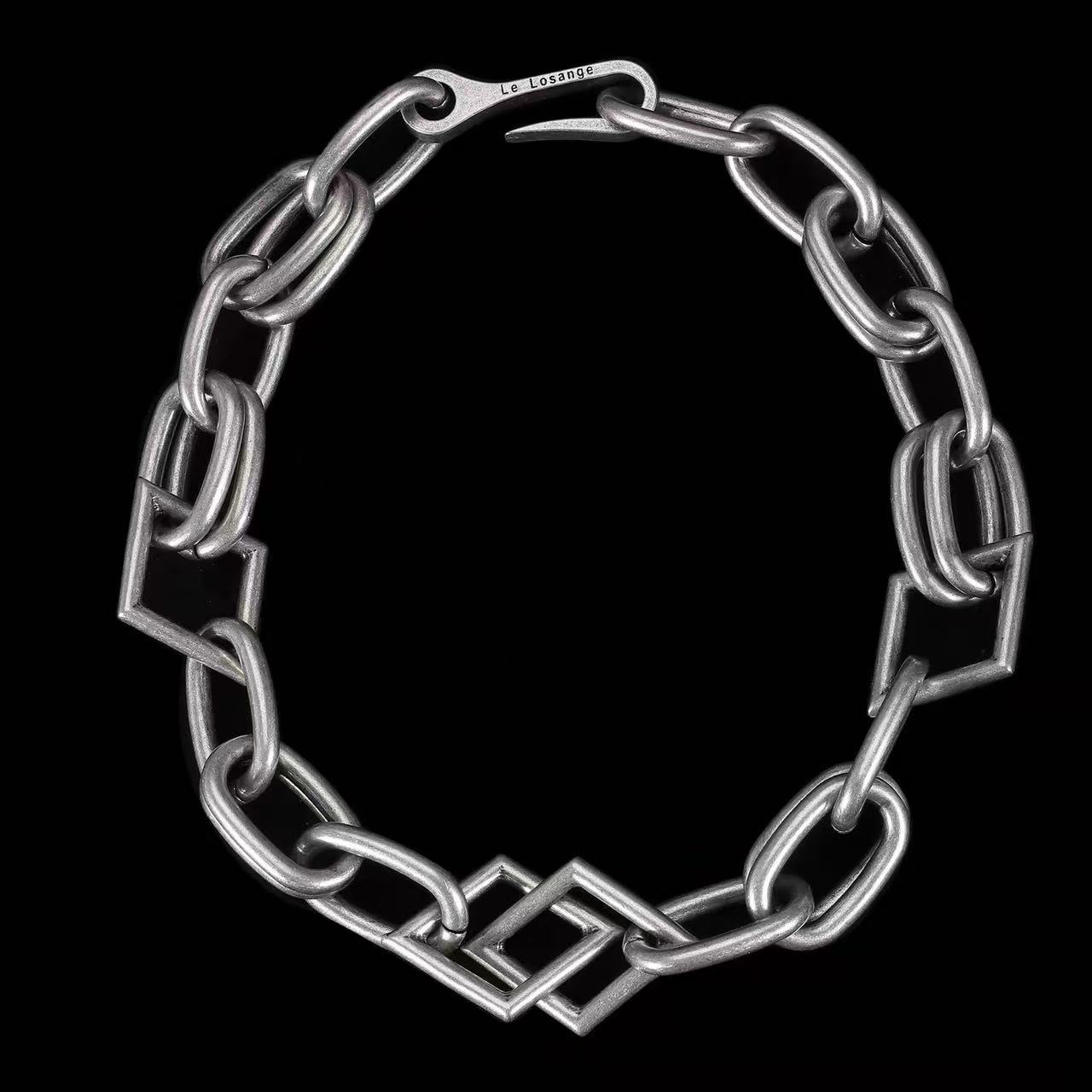 Silver geometric chain necklace on black