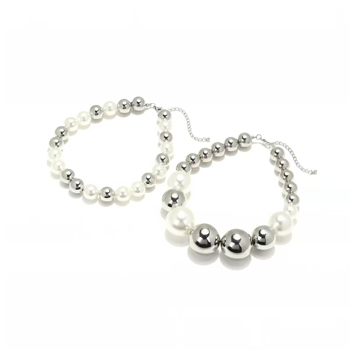 Pearl and polished silver necklaces on white